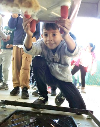 Samuel Delgadillo milks a fake cow