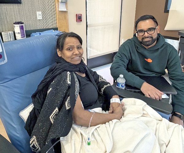Nevin Shoker sits with his mom Laxmi